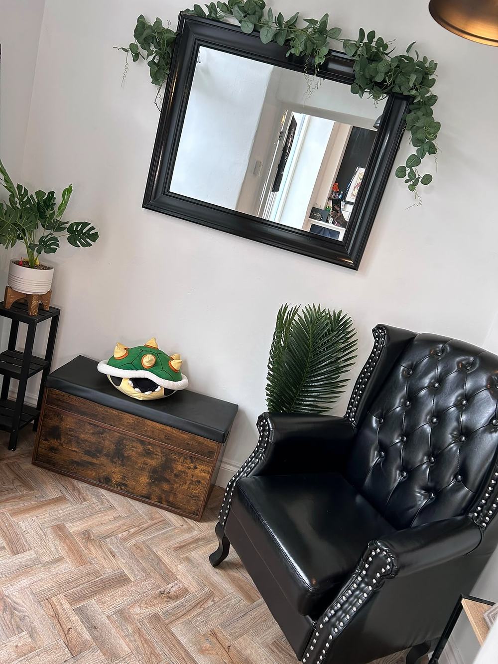 The waiting area with a leather armchair, mirror and plants
