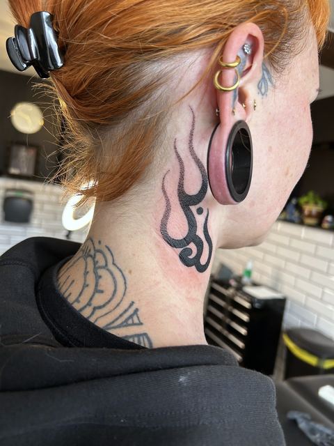 Ornamental neck tattoo with flame detail